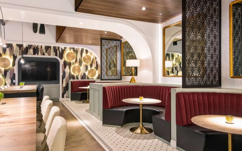 Resident clubhouse with ample seating, fireplace, demo kitchen and TVs