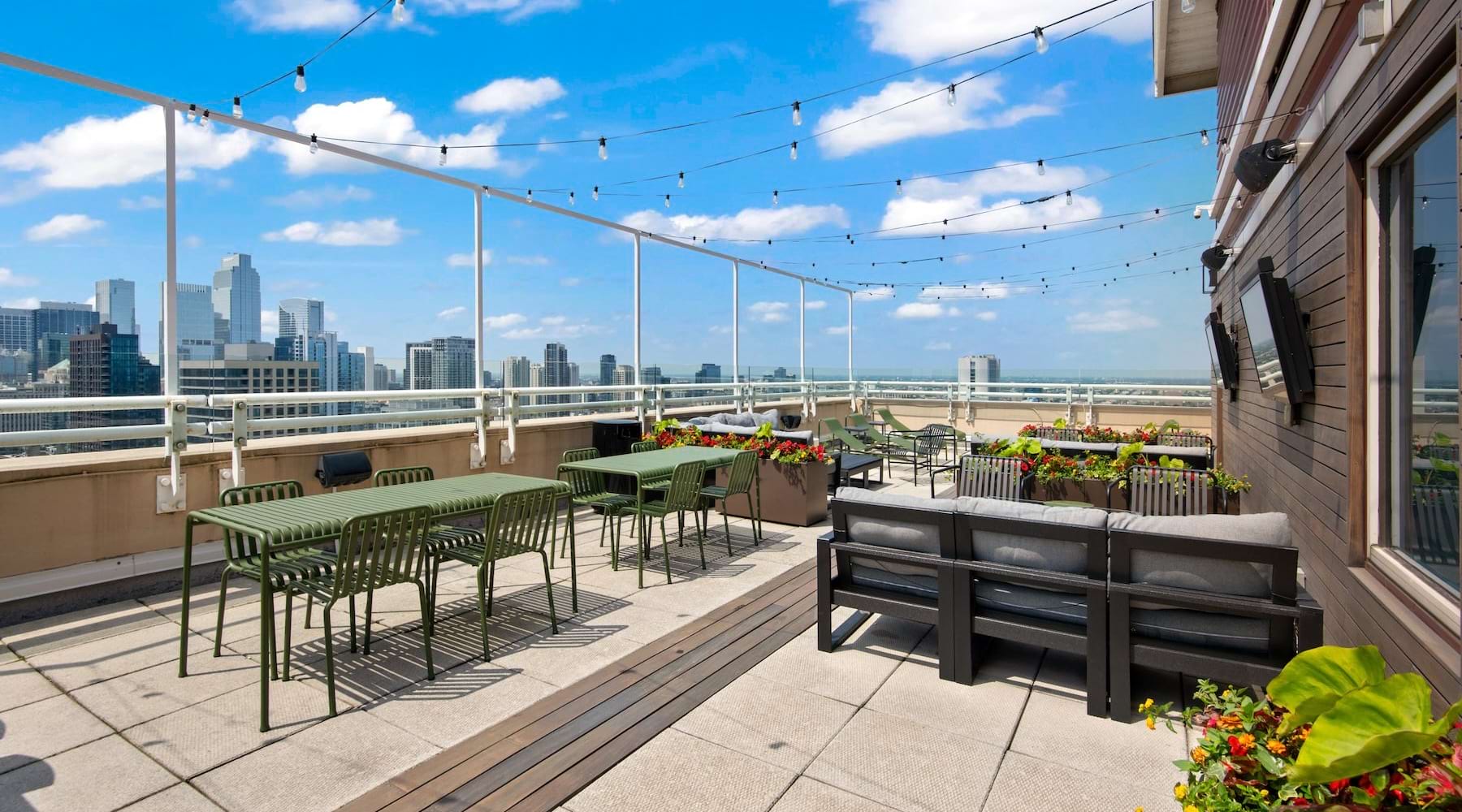 Rooftop terrace at Chestnut Tower with outdoor dining, lounge seating, and Chicago views