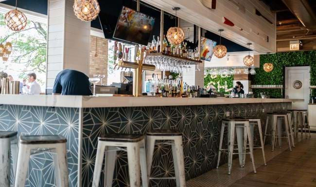 a bar with stools and a tv on the wall