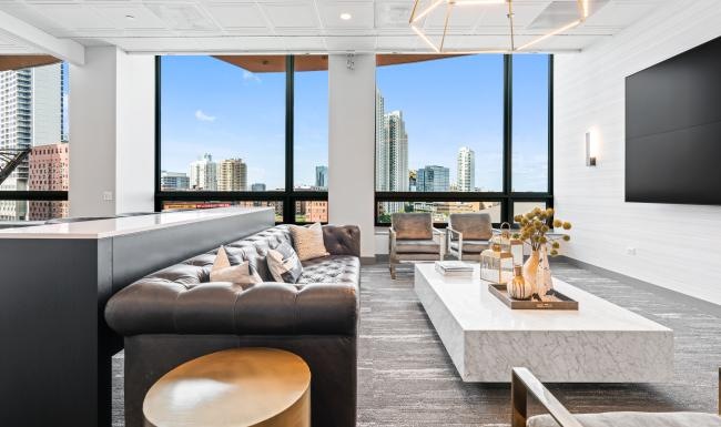 Spacious living room featuring floor‑to‑ceiling windows and city views at Hubbard Place apartments in Chicago.