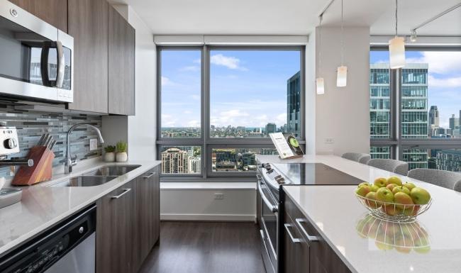 Modern kitchen with large window and high‑end finishes at Hubbard Place Chicago apartments.