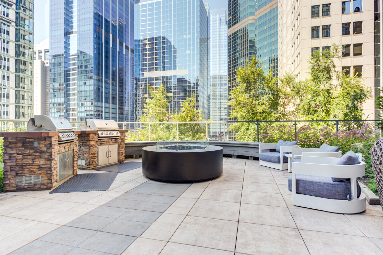 Terrace with grills, fireplace, and outdoor seating at Lake & Wells Chicago apartments