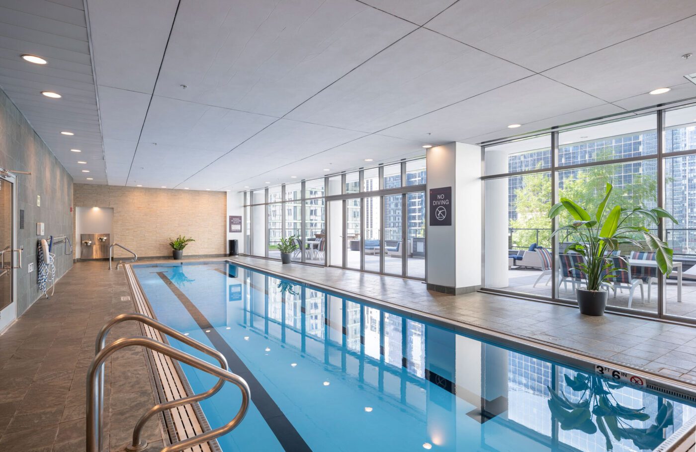 Indoor swimming pool with large windows at Lake & Wells apartments for rent in Chicago, IL.